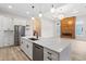 Open concept kitchen features quartz counters, stainless appliances and a wood accent wall with fireplace at 2205 Yellow Morel Way, Myrtle Beach, SC 29579