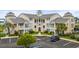Inviting exterior view of condo building showcasing manicured landscaping, ample parking, and classic coastal architecture at 222 Landing Rd. # 1811, North Myrtle Beach, SC 29582