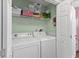 Compact laundry room featuring a washer, dryer, and storage shelf at 222 Landing Rd. # 1811, North Myrtle Beach, SC 29582