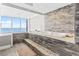 Beautiful bathroom featuring a large soaking tub with a stunning ocean view and stone tiled walls at 2500 N Ocean Blvd. # Ph 1, Myrtle Beach, SC 29577