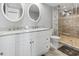 Bright bathroom featuring double sink vanity, round mirrors, tiled floors, and a walk-in shower at 2500 N Ocean Blvd. # Ph 1, Myrtle Beach, SC 29577