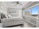 Relaxing bedroom with a ceiling fan, serene artwork, and a large window offering beautiful city views at 2500 N Ocean Blvd. # Ph 1, Myrtle Beach, SC 29577