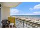 Relaxing balcony view overlooking the beach, ocean, and pool with chairs and table at 2801 S Ocean Blvd. # 535, North Myrtle Beach, SC 29582