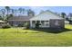 Exterior view of the back of the house featuring a green lawn, brick and white siding, and many windows at 2981 Victor Rd., Longs, SC 29568