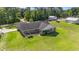 Picture of the backyard with a brick home, patio, landscaping, and grassy area with a partial fence at 2981 Victor Rd., Longs, SC 29568