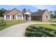 View of the front of the house with brick facade, a covered porch with columns, and a curved driveway at 2981 Victor Rd., Longs, SC 29568