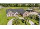 Aerial of brick house with circle drive, manicured lawn, and mature palm trees on a large, verdant lot at 2981 Victor Rd., Longs, SC 29568