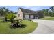 Two car garage next to a yard accented by plants, palms and a grill at 2981 Victor Rd., Longs, SC 29568