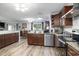Well-lit kitchen with wooden cabinetry, granite countertops, stainless steel appliances and dining area views at 2981 Victor Rd., Longs, SC 29568