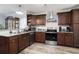 Well-equipped kitchen with dark wood cabinets, stainless steel appliances, and granite countertops at 2981 Victor Rd., Longs, SC 29568