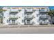Condominium building featuring multiple levels of balconies and a well-lit parking area with marked spaces at 300 47Th Ave. S # 1F, North Myrtle Beach, SC 29582