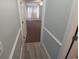 Hallway with wood-look flooring leads to a bedroom with textured carpet and a large window at 300 47Th Ave. S # 1F, North Myrtle Beach, SC 29582