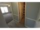 Hallway with wood-look flooring leads to a bedroom with textured carpet and large window at 300 47Th Ave. S # 1F, North Myrtle Beach, SC 29582