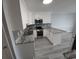 Bright kitchen featuring white cabinets, stainless steel appliances, granite countertops, and modern flooring at 300 47Th Ave. S # 1F, North Myrtle Beach, SC 29582