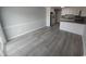 Living space with light gray flooring that flows into a kitchen area, featuring wainscoting and natural light at 300 47Th Ave. S # 1F, North Myrtle Beach, SC 29582