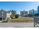 View from a deck of a vacant lot, nearby condos and blue sky on a sunny day at 300 47Th Ave. S # 1F, North Myrtle Beach, SC 29582
