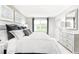 Bright bedroom featuring a large bed with decorative pillows and a white dresser with stylish mirror at 3210 Nw Edgemead Circle # C, Calabash, NC 28467