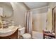 Well-lit bathroom features a toilet, shower-tub, and a circular mirror above a modern sink at 403 Chesterfield Ct., Myrtle Beach, SC 29577