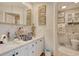 Nicely decorated bathroom featuring double sinks, framed pictures, and a toilet in a separate room at 4396 Baldwin Ave. # 1, Little River, SC 29566