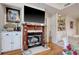 Close-up of the fireplace with the black fireplace door, dark wood accents, and light-colored mantel and hearth at 4396 Baldwin Ave. # 1, Little River, SC 29566