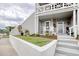 Charming front porch with white chairs, flowers, and lush landscaping provides an inviting entrance to this lovely home at 4396 Baldwin Ave. # 1, Little River, SC 29566