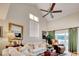 Bright living room with vaulted ceilings, neutral paint, a ceiling fan, large windows, and sliding glass door access to the outside at 4396 Baldwin Ave. # 1, Little River, SC 29566