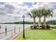 Scenic waterfront view with palm trees, green lawn, and a secure chain-link fence at 4396 Baldwin Ave. # 1, Little River, SC 29566