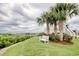 Picturesque waterfront featuring a bench under palm trees, complemented by red roses and lush green grass at 4396 Baldwin Ave. # 1, Little River, SC 29566