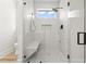 Sleek walk-in shower with a built-in bench, pebble flooring, glass enclosure, and a rainfall showerhead at 4617 Hedrick St., North Myrtle Beach, SC 29582