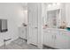 Bright bathroom featuring dual sink vanities, tile flooring, white cabinets, and a glass-enclosed shower at 462 Pacific Commons Dr., Surfside Beach, SC 29575