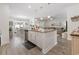 Bright kitchen with white cabinets, granite countertops, a large island, and an adjacent dining and living area at 462 Pacific Commons Dr., Surfside Beach, SC 29575