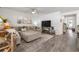 Stylish living room with a sectional sofa, a large TV, and hardwood floors leading to the hallway at 462 Pacific Commons Dr., Surfside Beach, SC 29575