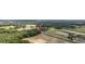 Aerial shot showcases property amidst fields, ponds, and lush forests under a sunny sky at 4860 Highway 378, Conway, SC 29527