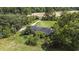 Aerial shot featuring a modest house amid mature trees, a long driveway, and expansive green space at 4860 Highway 378, Conway, SC 29527