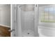 Bright bathroom with a shower-tub combo and a white shower curtain next to a clear glass window at 5115 Huston Rd., Conway, SC 29526