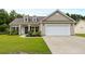 Charming one-story home with well-maintained lawn, neutral siding, and a two car attached garage at 5115 Huston Rd., Conway, SC 29526