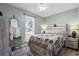 Cozy bedroom features a queen bed with a patterned blanket, wood-look floors and a ceiling fan at 517 Cardinal Dr., Conway, SC 29526