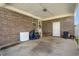Spacious brick carport featuring a white door, concrete flooring, and overhead lighting for outdoor storage and convenience at 517 Cardinal Dr., Conway, SC 29526