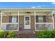 Inviting front porch with charming seating, decorative elements, and a ceiling fan for a relaxed, welcoming entrance at 517 Cardinal Dr., Conway, SC 29526