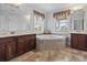 Well-lit bathroom with dual vanities, a soaking tub with marble surround, and tile flooring at 5407 N Ocean Blvd., Myrtle Beach, SC 29577
