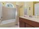 Bright bathroom featuring a bathtub with tile surround and a single sink vanity with wood cabinetry at 5407 N Ocean Blvd., Myrtle Beach, SC 29577