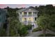 Charming two-story home with double balconies and lush tropical landscaping offers inviting curb appeal at 5407 N Ocean Blvd., Myrtle Beach, SC 29577
