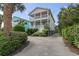 Inviting two-story home with dual balconies, complemented by lush landscaping and a spacious driveway at 5407 N Ocean Blvd., Myrtle Beach, SC 29577
