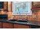 Detailed view of the kitchen sink, granite counters, and tile backsplash at 5407 N Ocean Blvd., Myrtle Beach, SC 29577