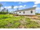 Exterior of a home with minimal landscaping and a small deck at the rear at 565 Kent Rd., Georgetown, SC 29440