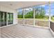 Covered porch showcasing spacious wood-look flooring and views of the yard beyond the black iron railing at 565 Kent Rd., Georgetown, SC 29440