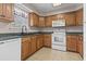 Functional kitchen features wood cabinets, white appliances, and tile flooring at 568 Rosedale Dr., Aynor, SC 29511