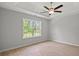 Bedroom with large window, tray ceiling, ceiling fan, and plank flooring at 600 Woodside Dr., Conway, SC 29526