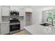 Well-equipped kitchen with stainless appliances, quartz countertops, and bright white cabinets at 600 Woodside Dr., Conway, SC 29526