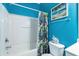 Bathroom with blue walls, shower-tub combo with a tropical-themed shower curtain, and vanity sink at 604 Heathrow Dr. # 1101, Myrtle Beach, SC 29579